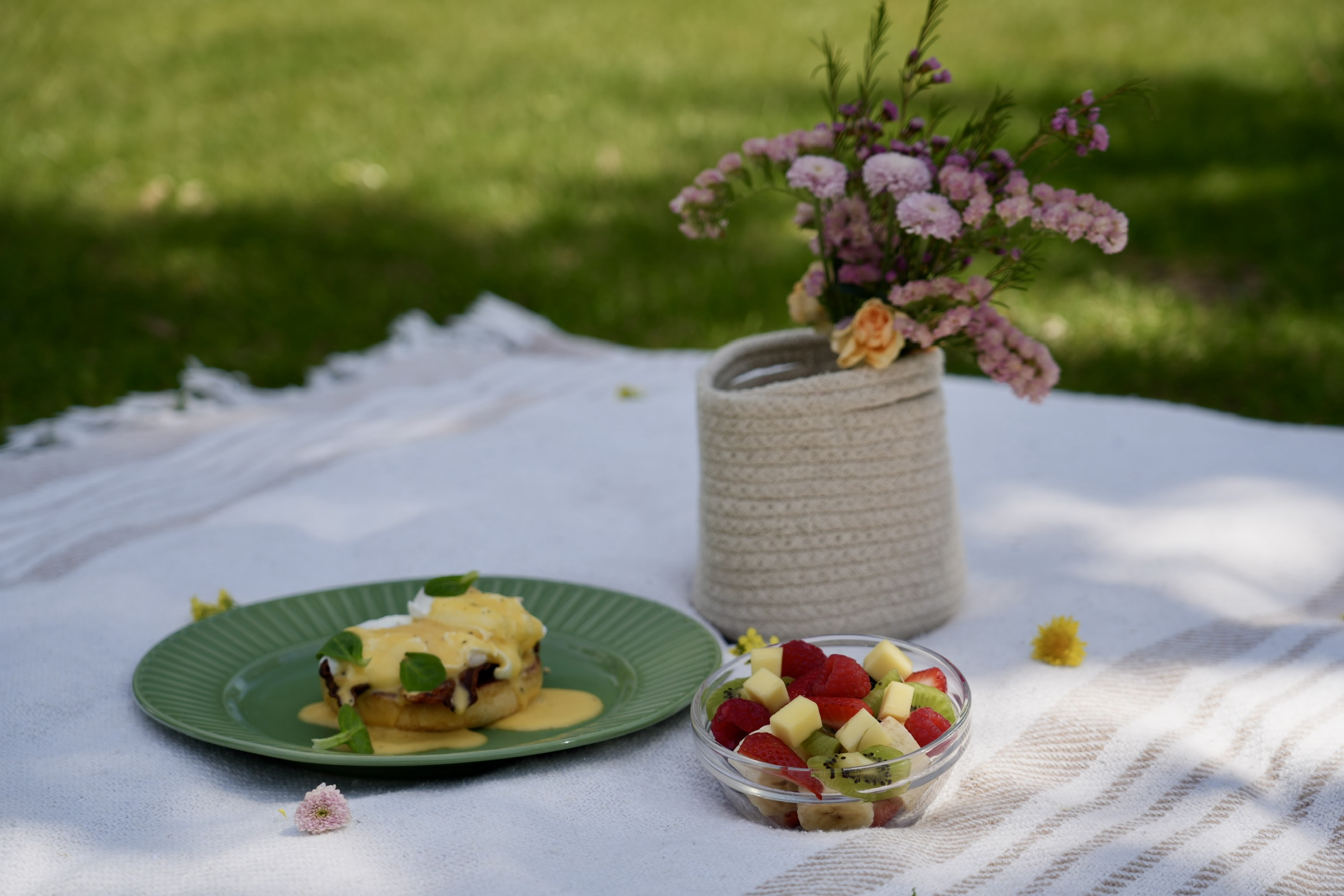 Eggs Benedict with fruit salad in a picnic setting — private chef Mallorca